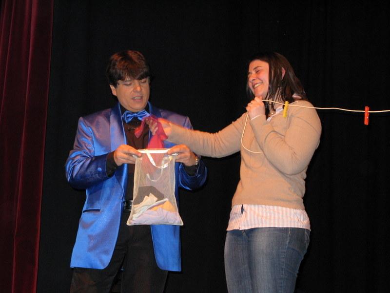 Magicien Olivier OK MAGICS présentant un tour interactif avec une spectatrice comique durant le Jubilée Show à Bruxelles 2010