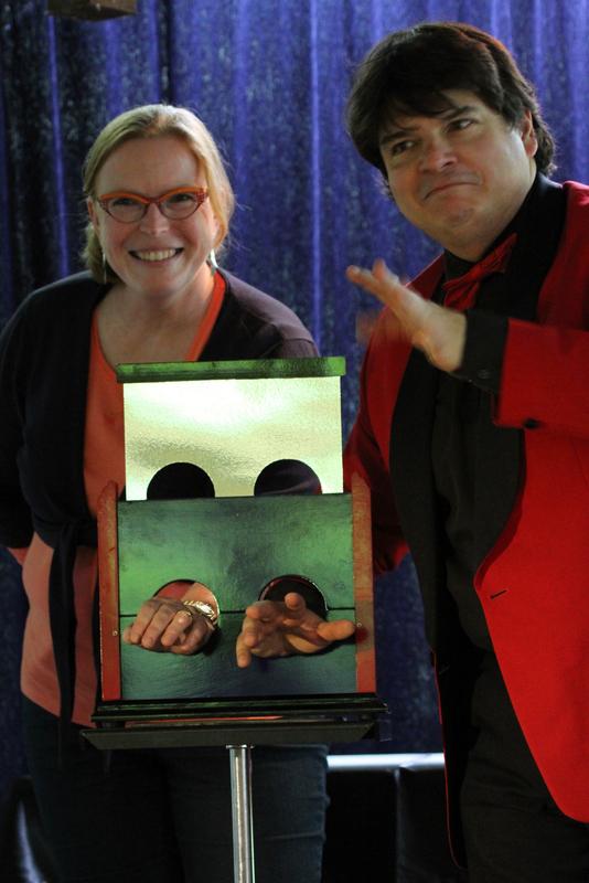 Magicien Olivier OK MAGICS présentant l'illusion Armcutter avec une spectatrice en Belgique 2014 