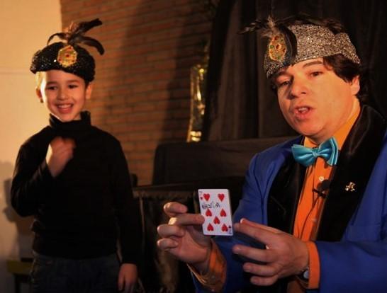 Zauberer Olivier OK MAGICS zaubert mit einem Jungen während eines Bühnenauftritts in Brüssel 2009