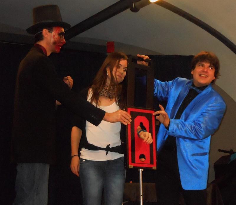 Magician Olivier OK MAGICS performt die Armguillotine mit Zuschauerin während der Halloween Tour 2013